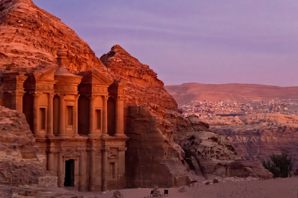 The famous Ad Deir, often also refered to as Monastery, in the ancient nabbatean city of Petra in Jordan at sunset with a view to the city of Wadi Musa. 